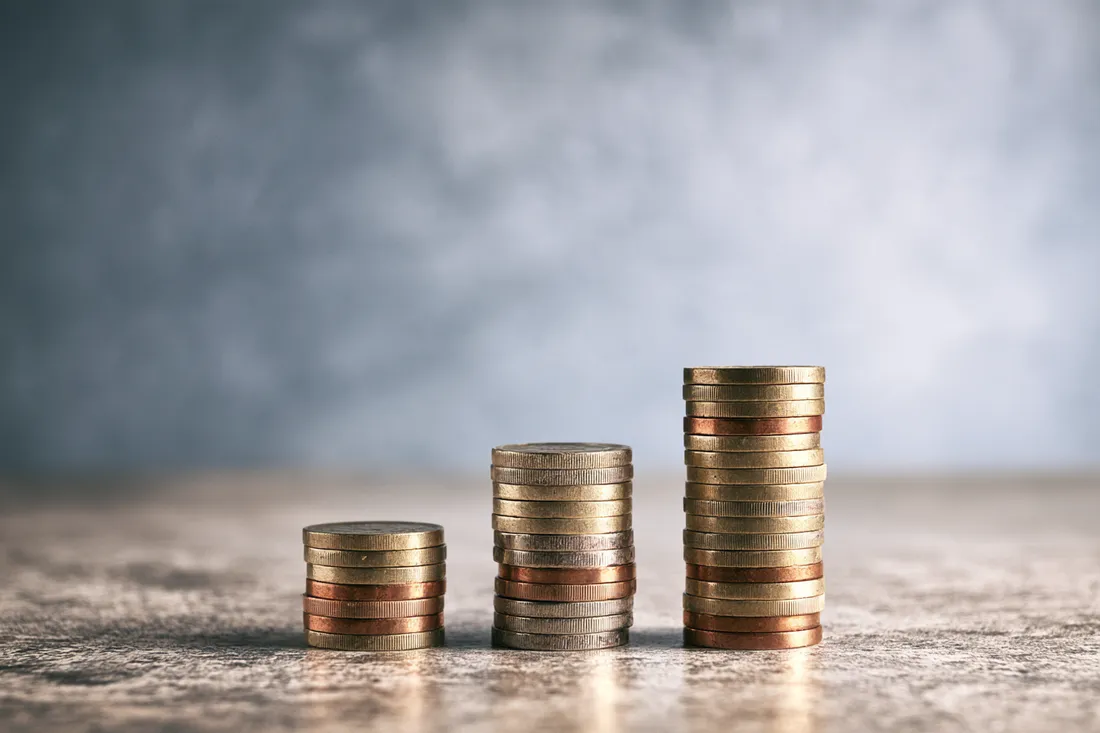 Three rising coin stacks representing a larger installment loan